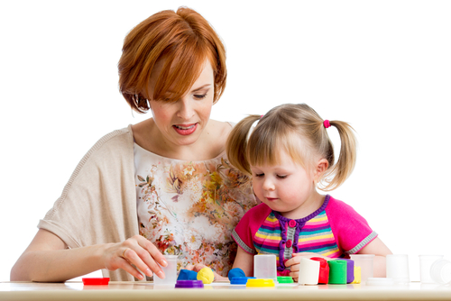 woman and young girl with clear cups and small colorful objects
